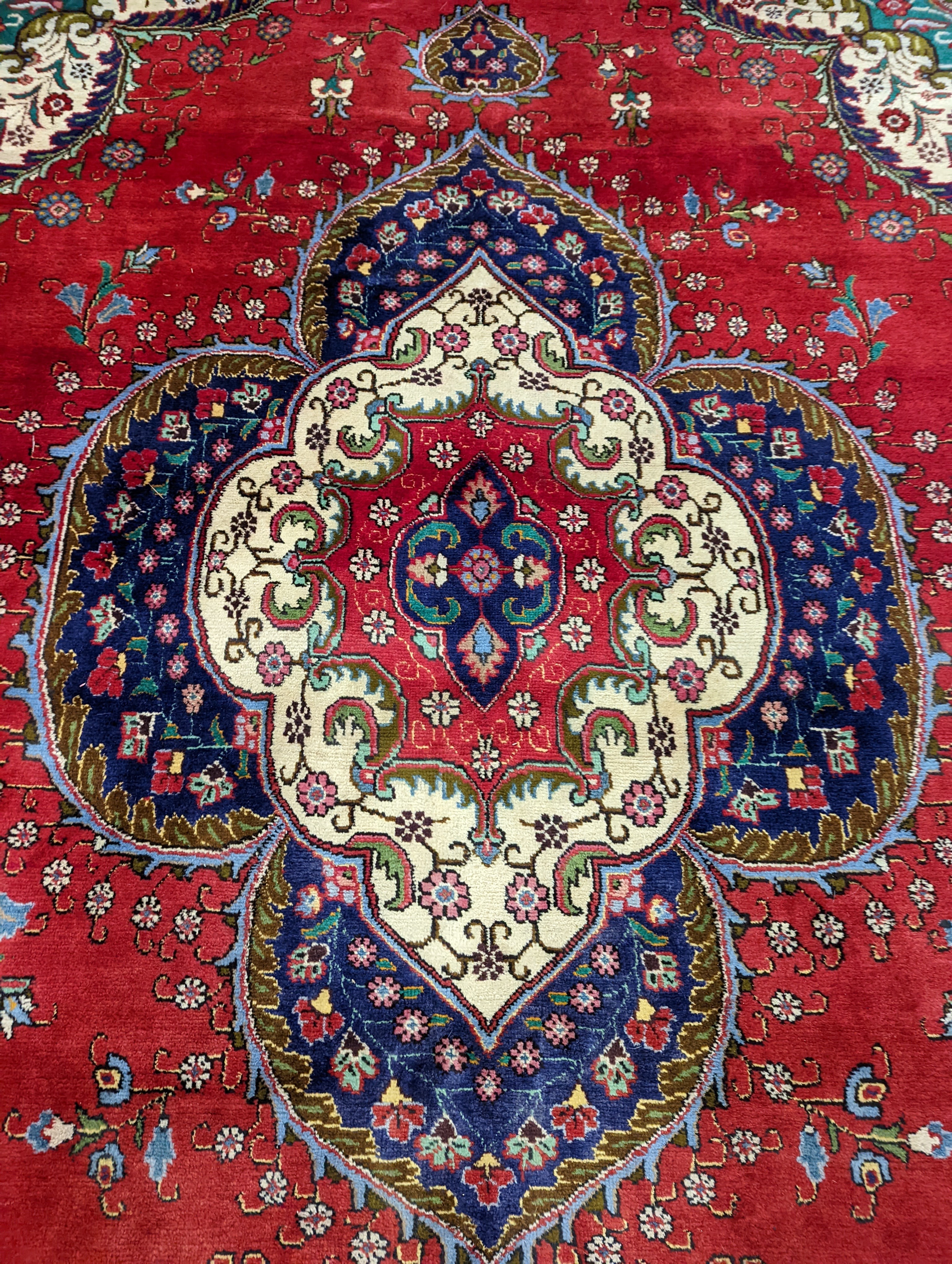 A Tabriz red ground carpet, 380 x 300cm